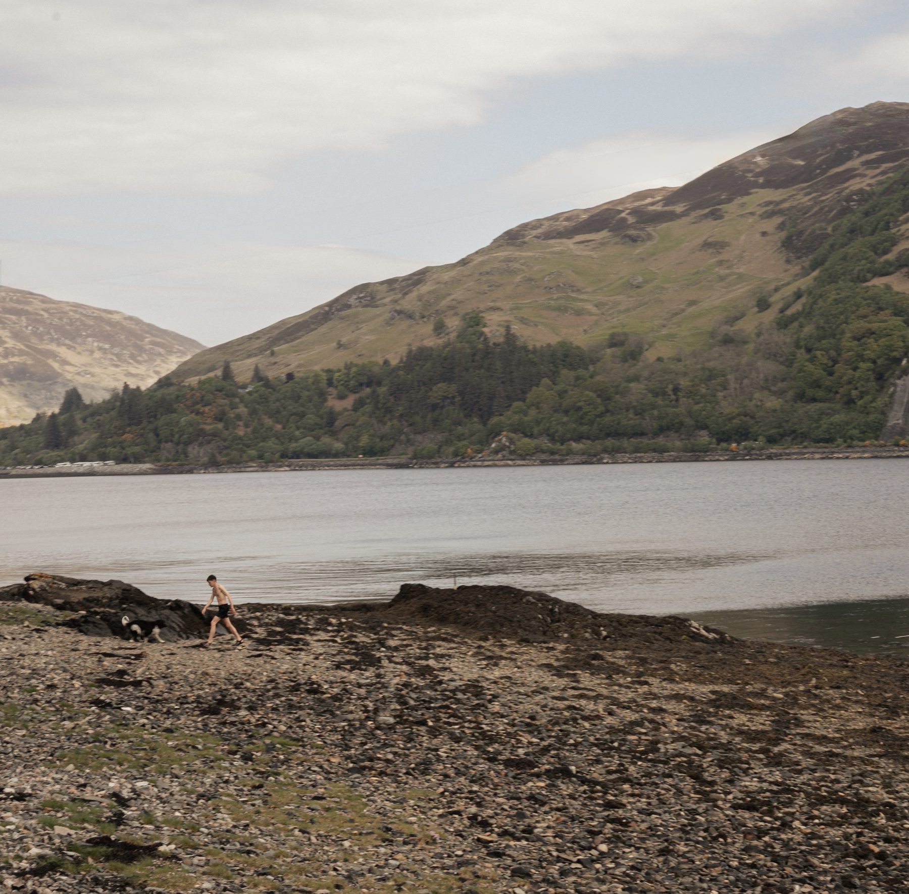 Children swimming and paddling on the shore of Loch Duich