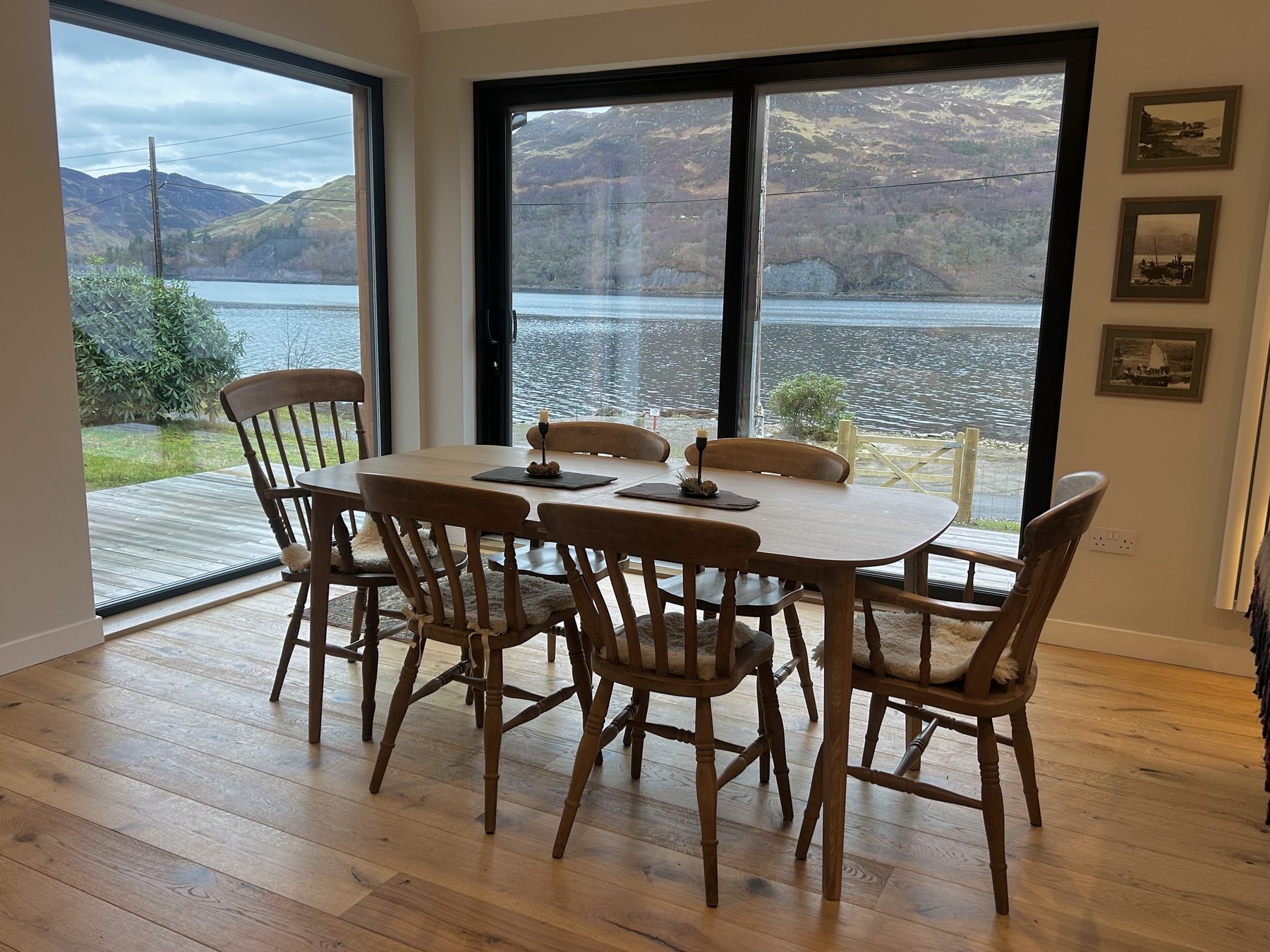 Dining area with full-height sliding glass doors opening onto the loch